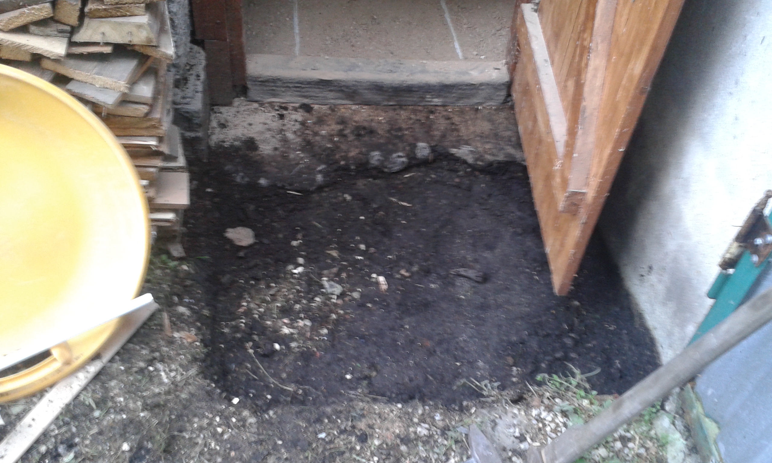 Oczyszczony fragment terenu przy wejściu do pomieszczenia po usunięciu starej nawierzchni, z widocznym przygotowaniem gruntu do dalszych prac.