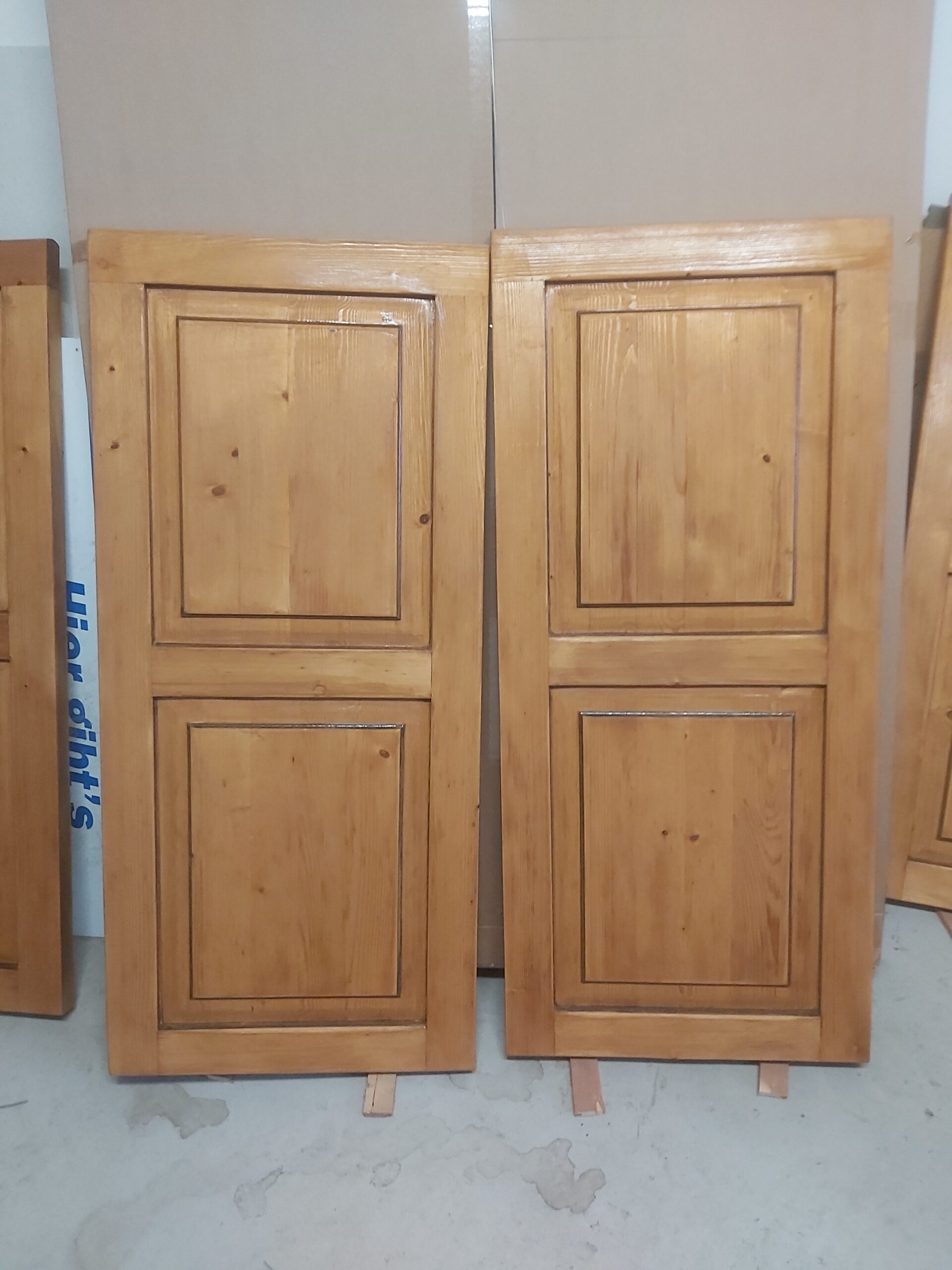 Dwa drewniane fronty meblowe ustawione pionowo obok siebie, z odnowioną, gładką powierzchnią i widocznym naturalnym usłojeniem drewna.