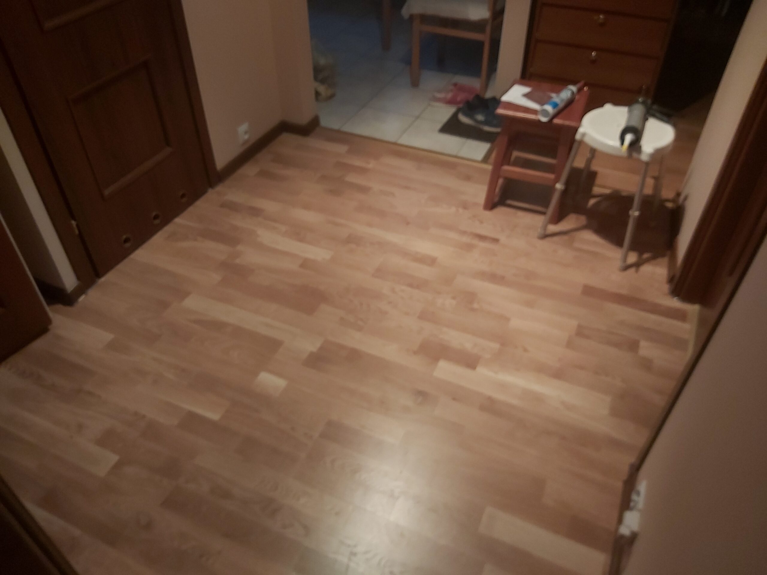 Widok na nowo ułożoną podłogę laminowaną w korytarzu mieszkania podczas prac wykończeniowych