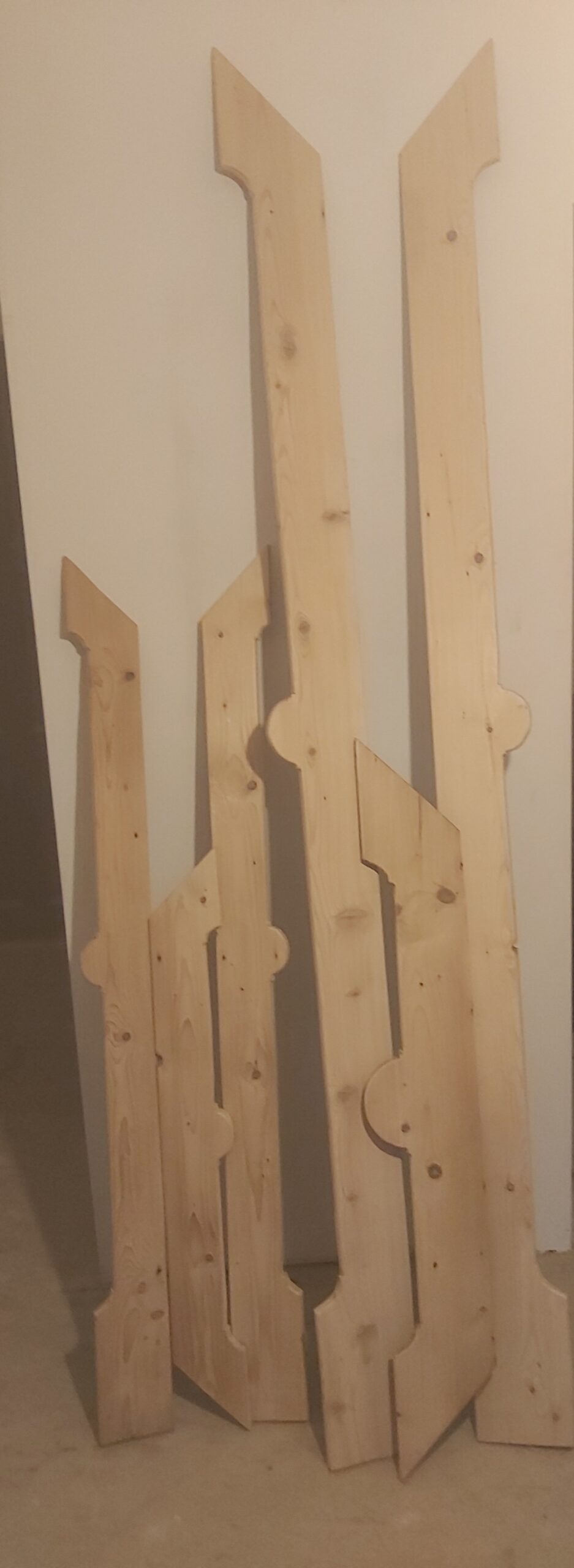 Przygotowane i docięte nowe drewniane elementy konstrukcyjne balkonu, ustawione pionowo przed montażem.