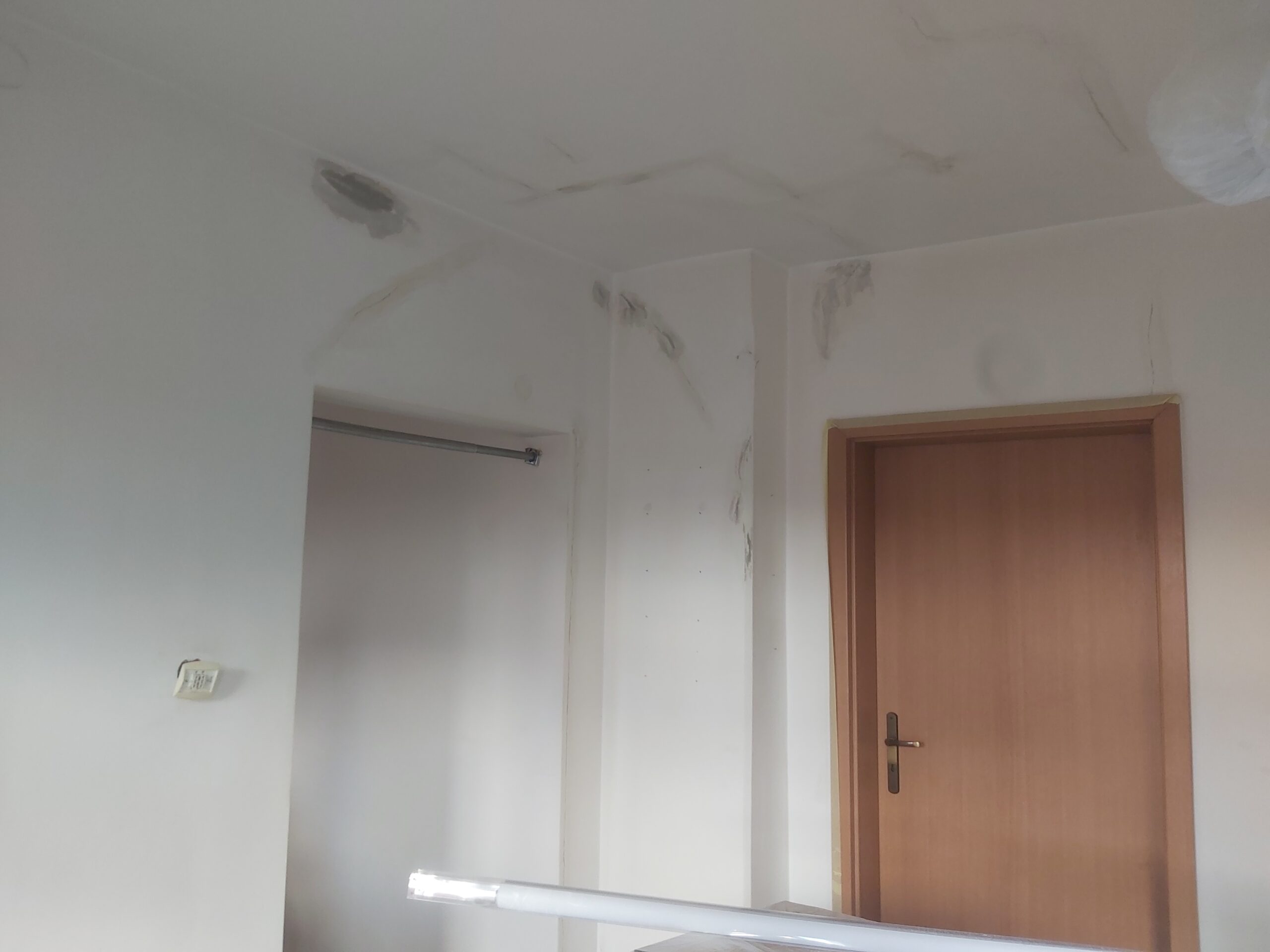 Sufit i ściany w trakcie naprawy, widoczne ślady szpachlowania i przygotowania powierzchni przed dalszymi pracami wykończeniowymi.