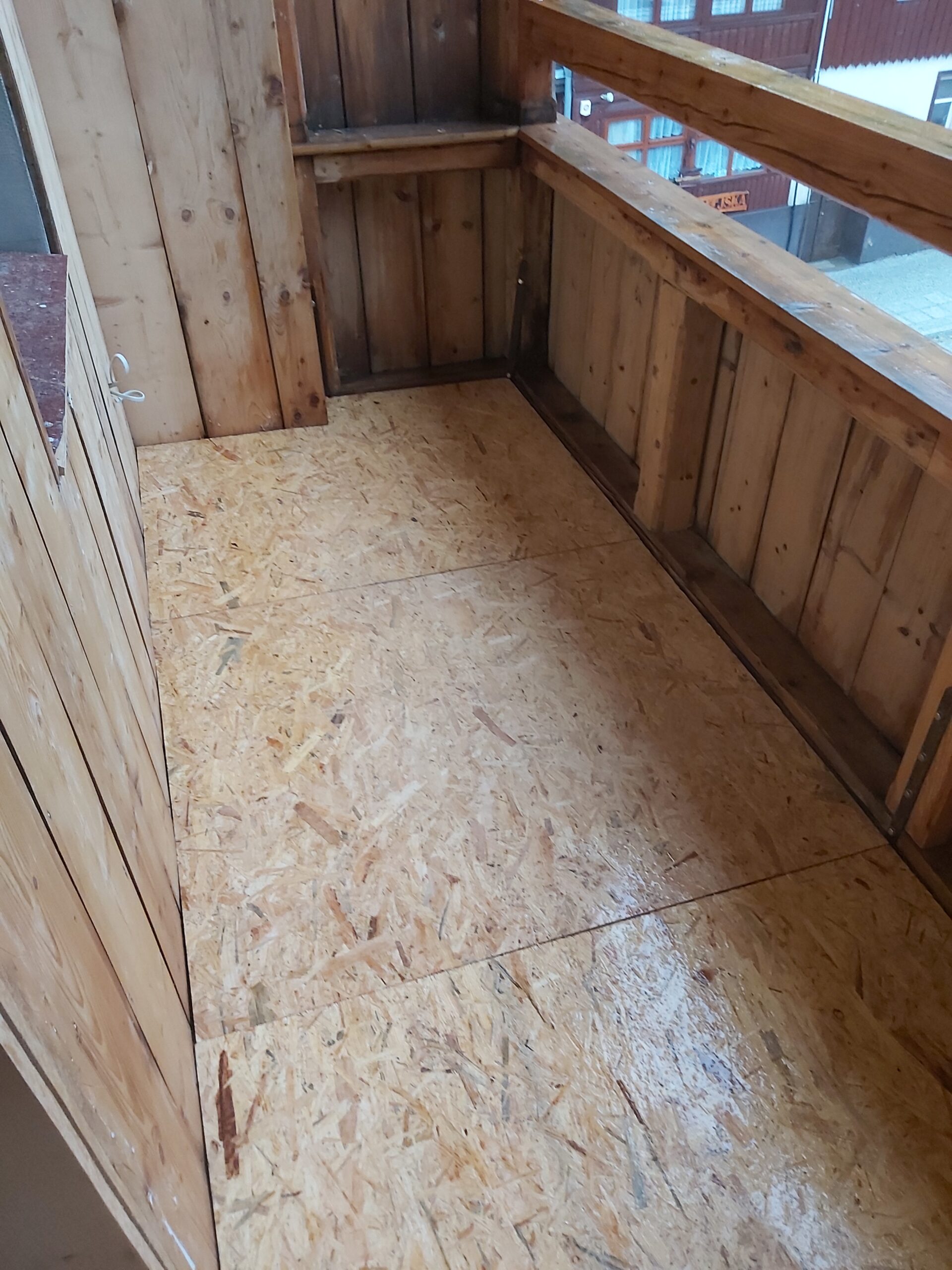 Podłoga balkonu wyłożona płytą OSB w narożnej części, stan po wyrównaniu i przygotowaniu pod dalsze prace wykończeniowe.