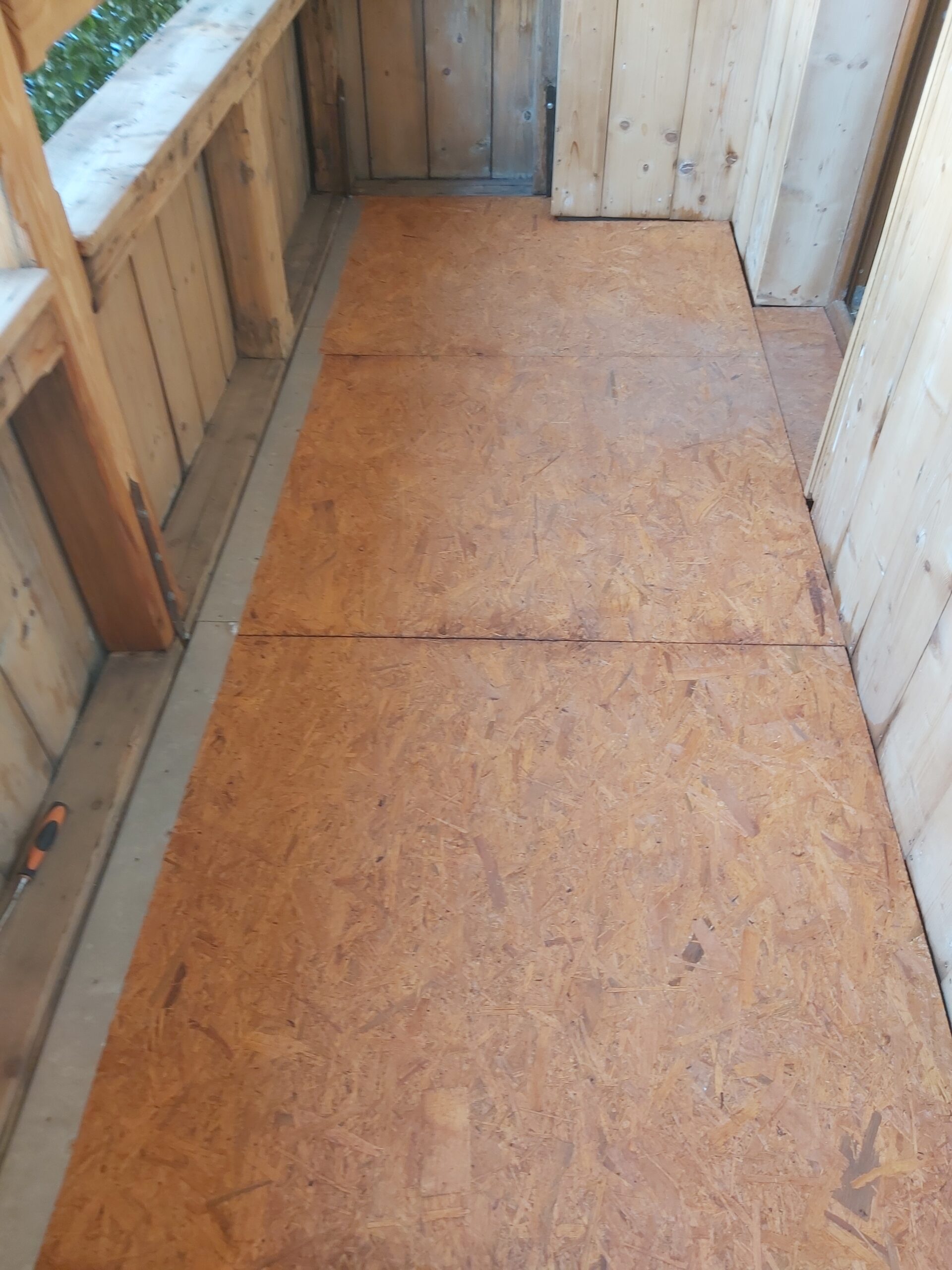 Płyty OSB ułożone na podłodze balkonu, przygotowane jako stabilny podkład pod dalsze wykończenie.