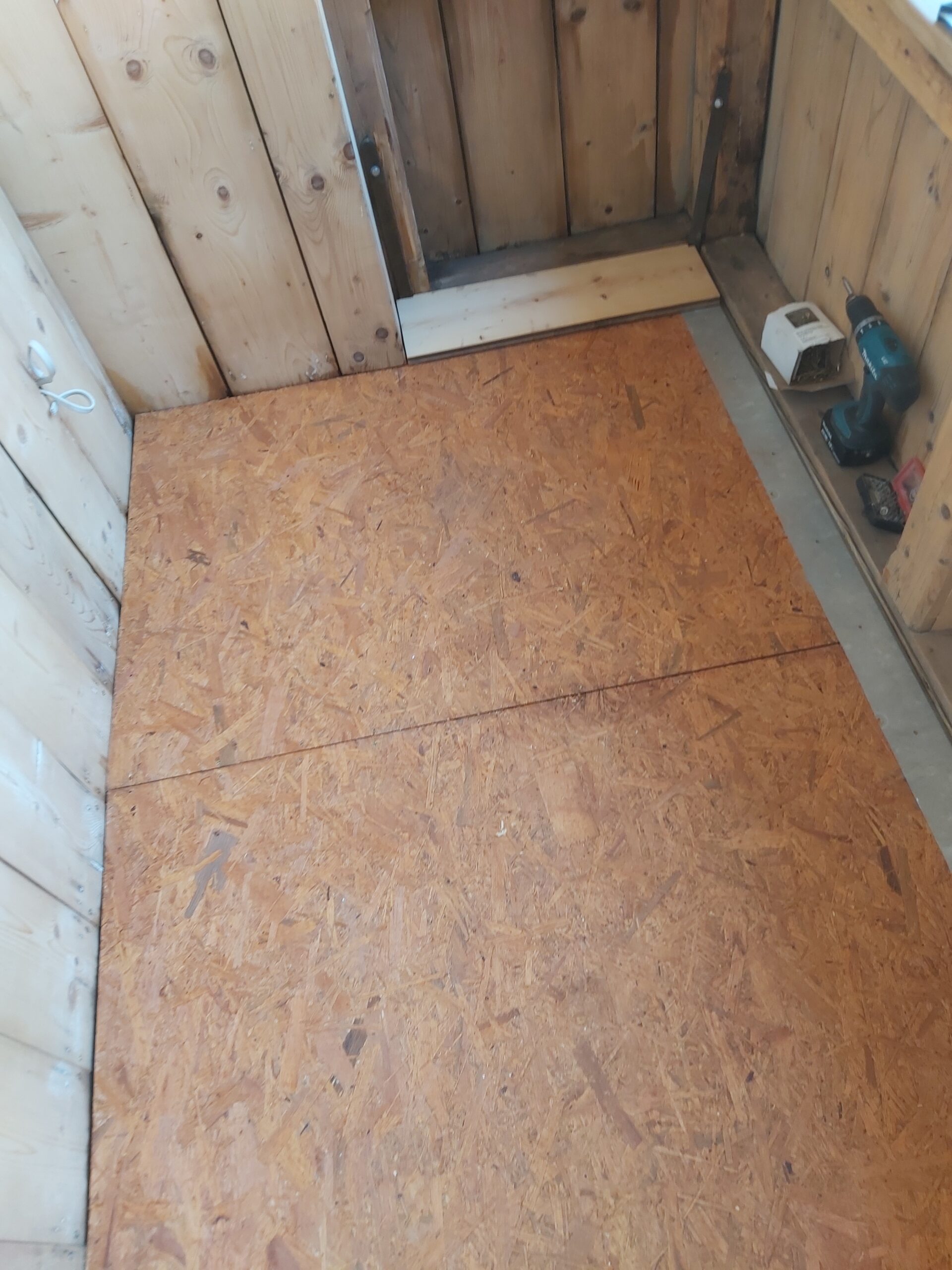 Płyty OSB ułożone na podłodze balkonu jako przygotowanie pod montaż drewnianych desek podłogowych.