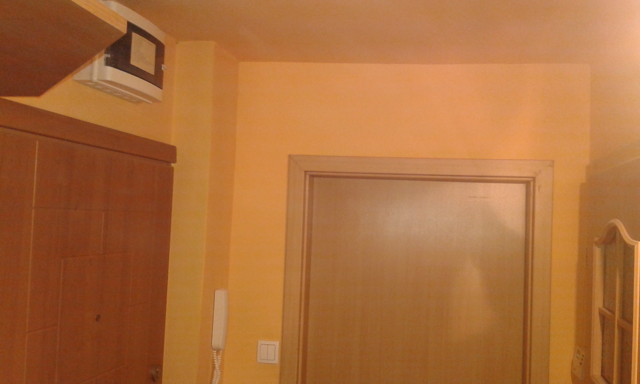 Korytarz z żółtymi ścianami i drzwiami wejściowymi po zakończonych pracach wykończeniowych