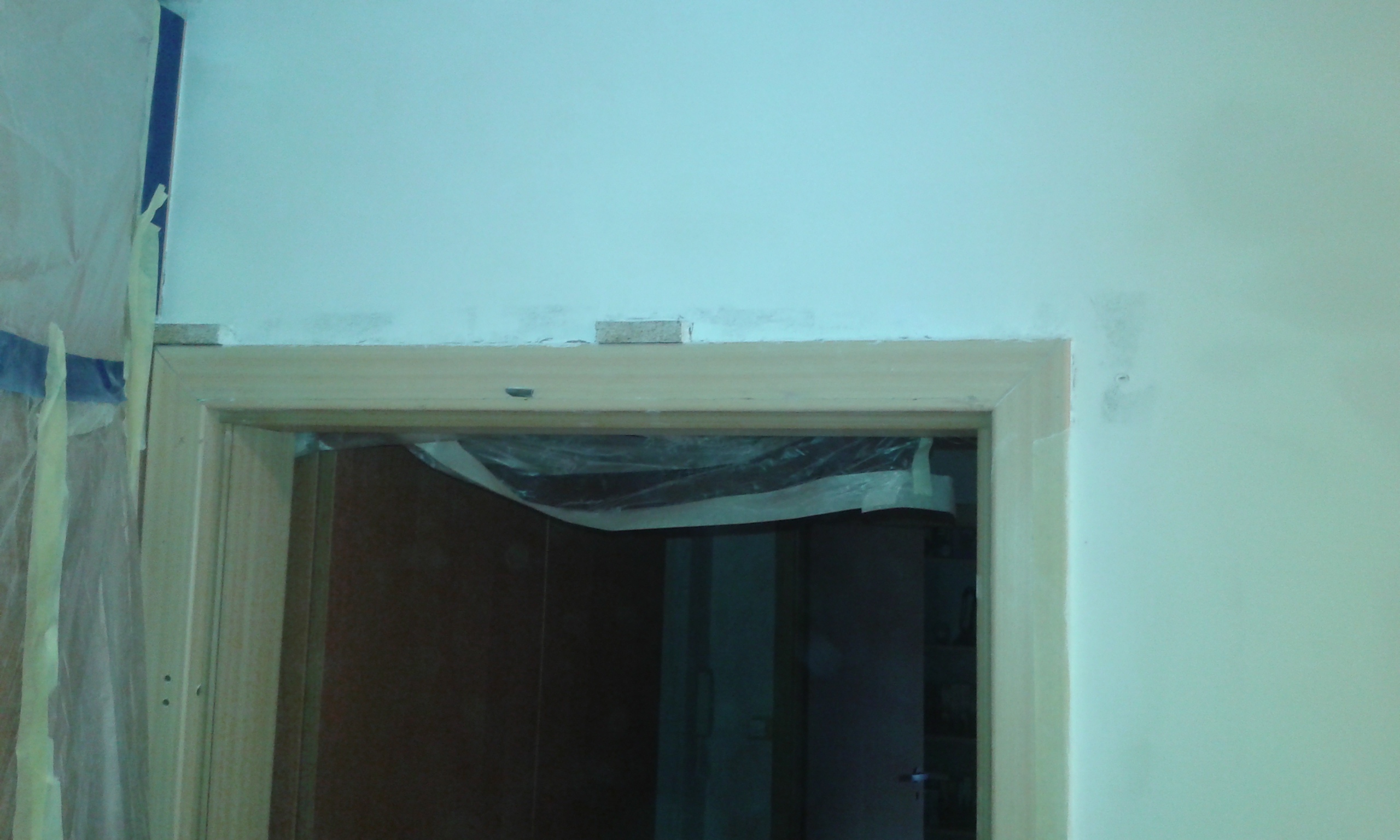 Górna część otworu drzwiowego z ościeżnicą podczas prac remontowych