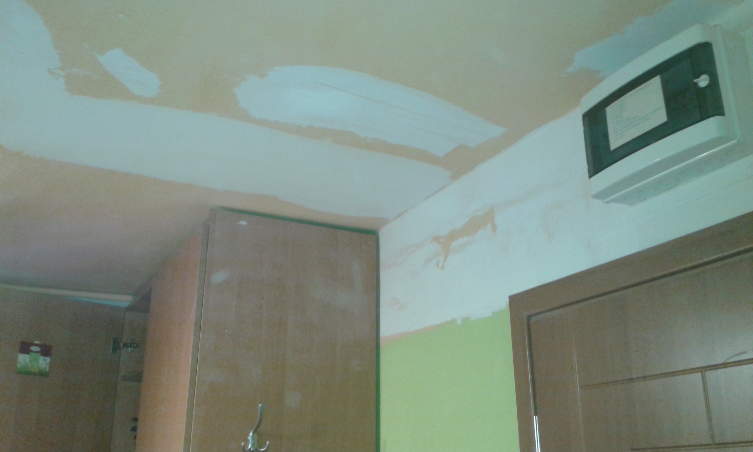 Fragment sufitu i ściany przy drzwiach z widocznymi poprawkami szpachlarskimi