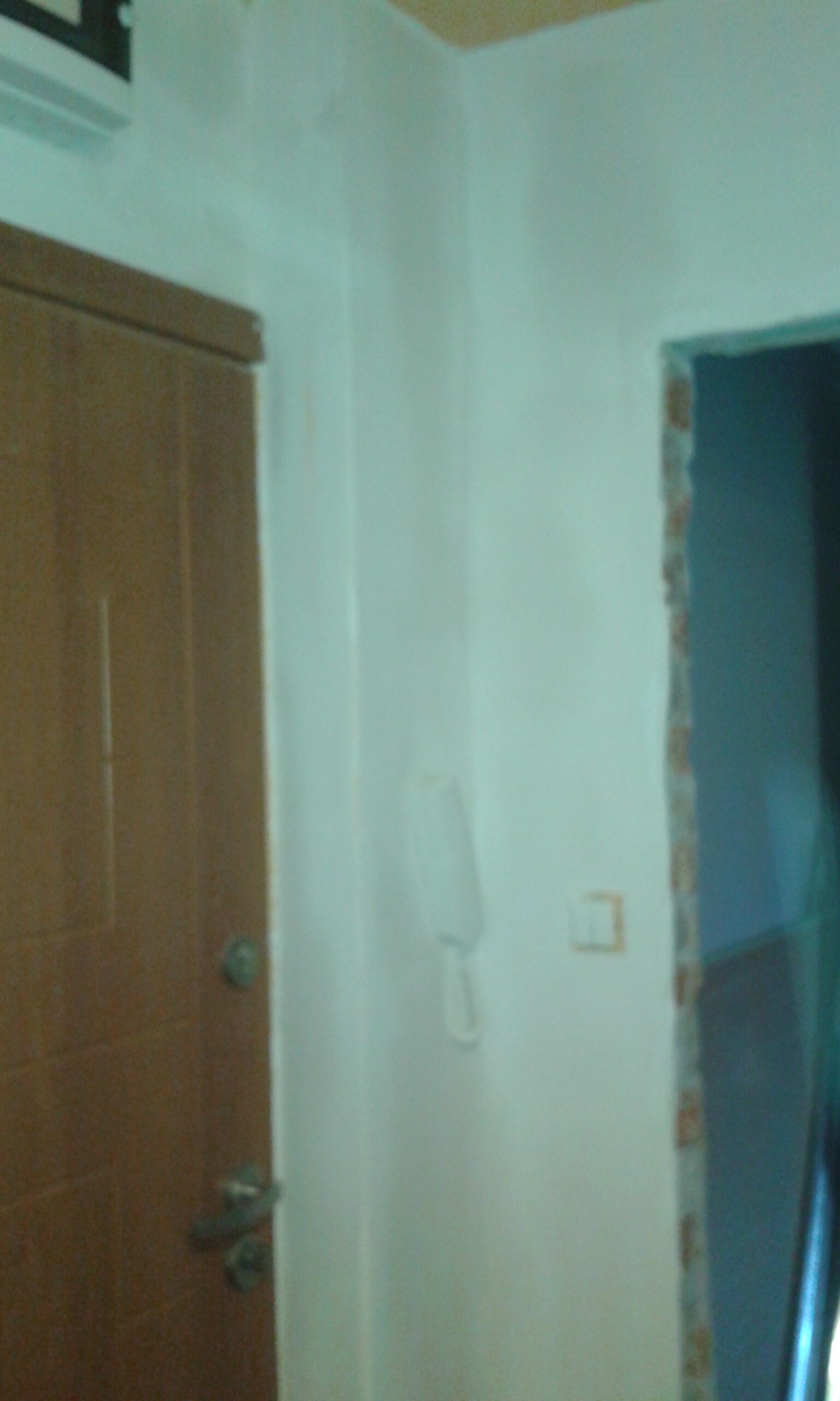 Ściana wewnętrzna po szpachlowaniu przy drzwiach wejściowych i otworze drzwiowym