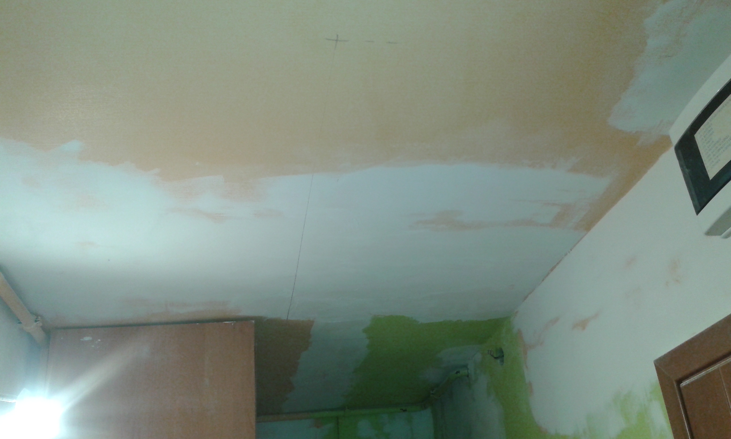 Sufit z płyt gipsowo-kartonowych po szpachlowaniu i gruntowaniu w trakcie wykończenia wnętrza