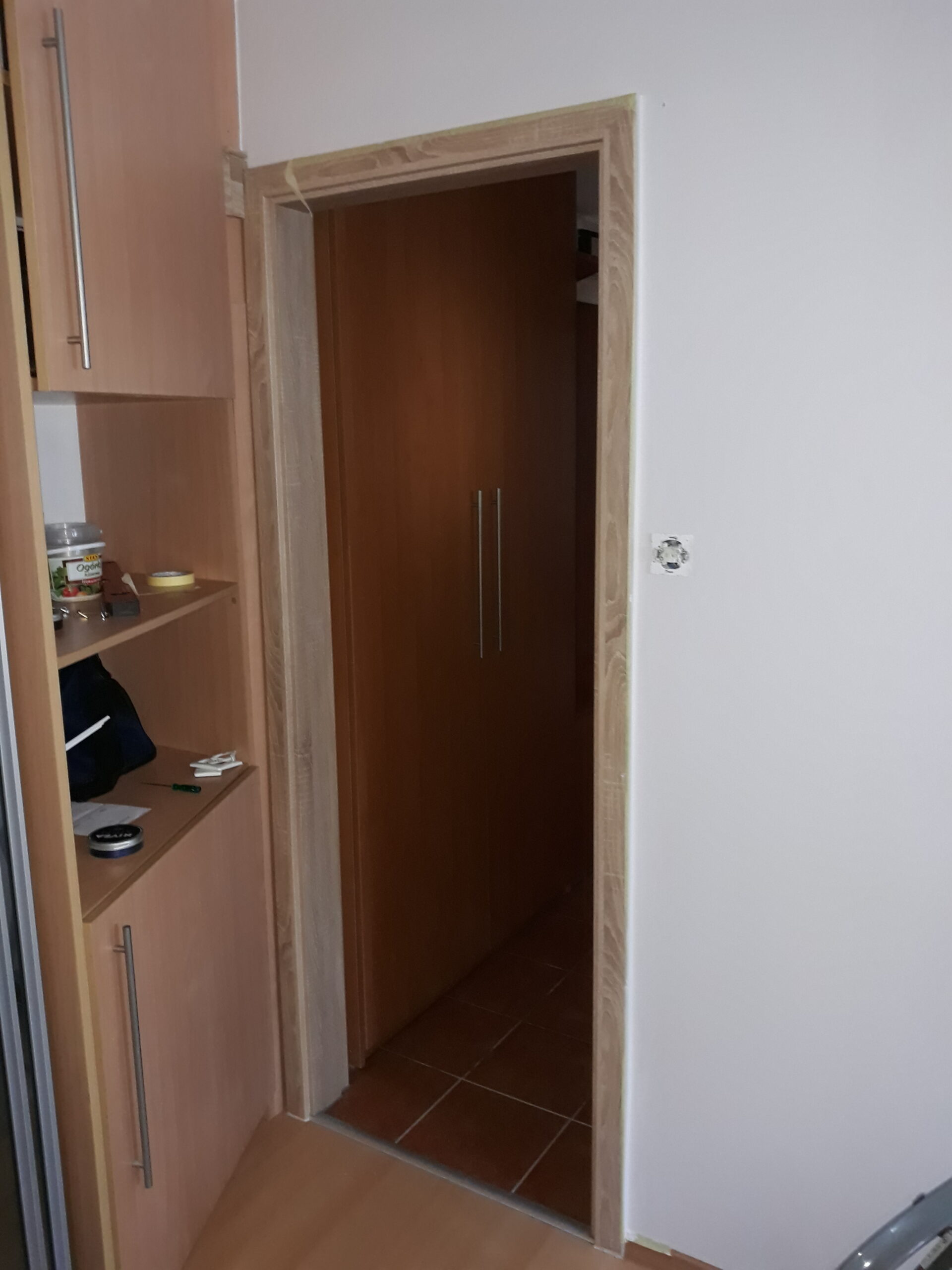 Zamontowana ościeżnica drzwiowa w jasnym wykończeniu, osadzona w ścianie po pracach przygotowawczych i przed finalnym wykończeniem wnętrza.