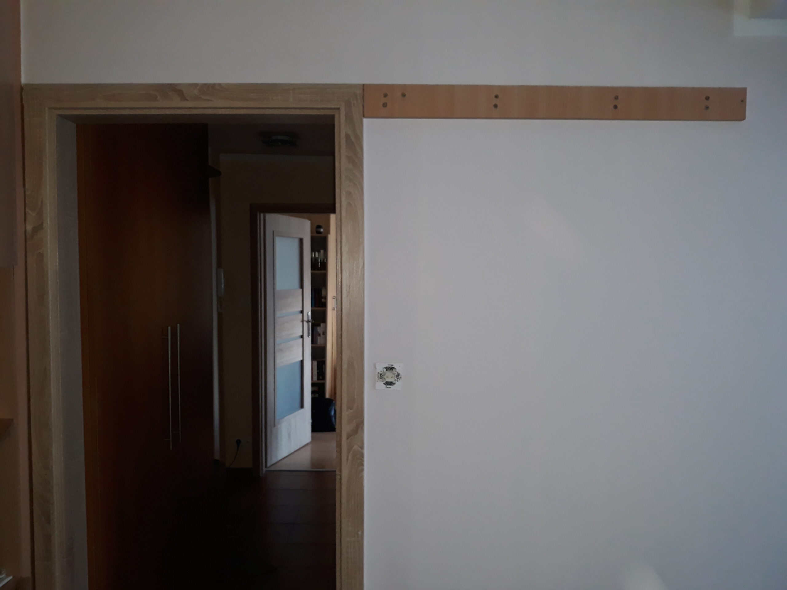 Otwór drzwiowy z zamontowaną listwą montażową nad ościeżnicą, przygotowany do dalszych prac stolarskich i wykończeniowych.