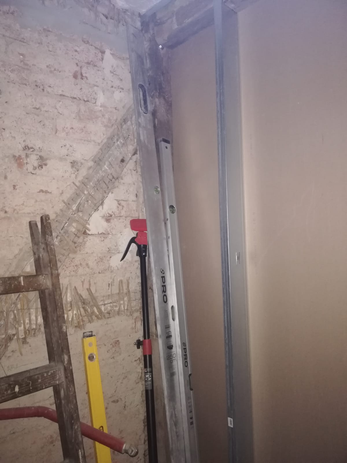 Profil metalowy konstrukcji ściany działowej przy otworze drzwiowym podczas remontu poddasza