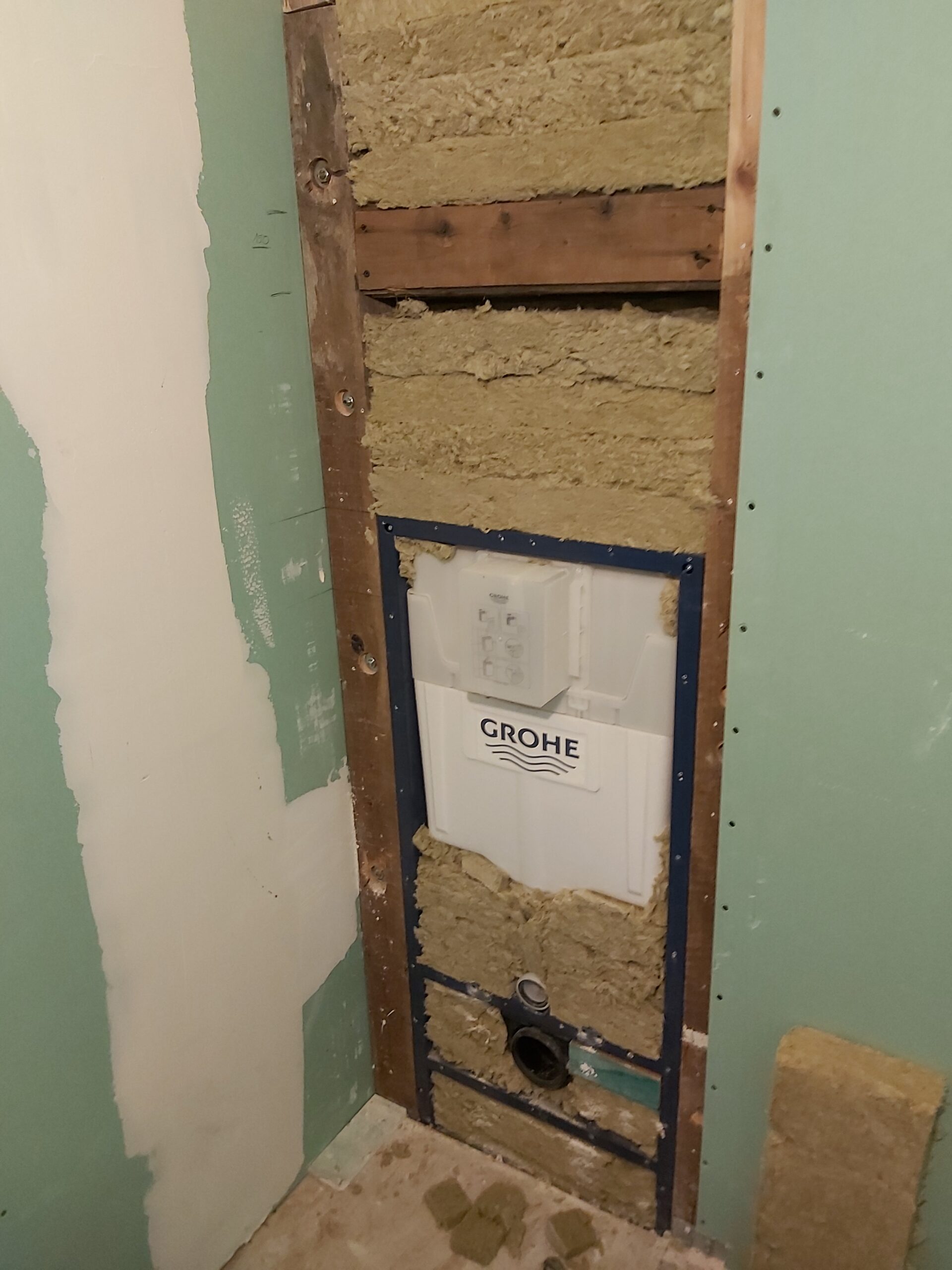 Stelaż podtynkowy WC Grohe w ścianie łazienki, widoczna konstrukcja, izolacja i przygotowanie pod zabudowę płytami g-k.