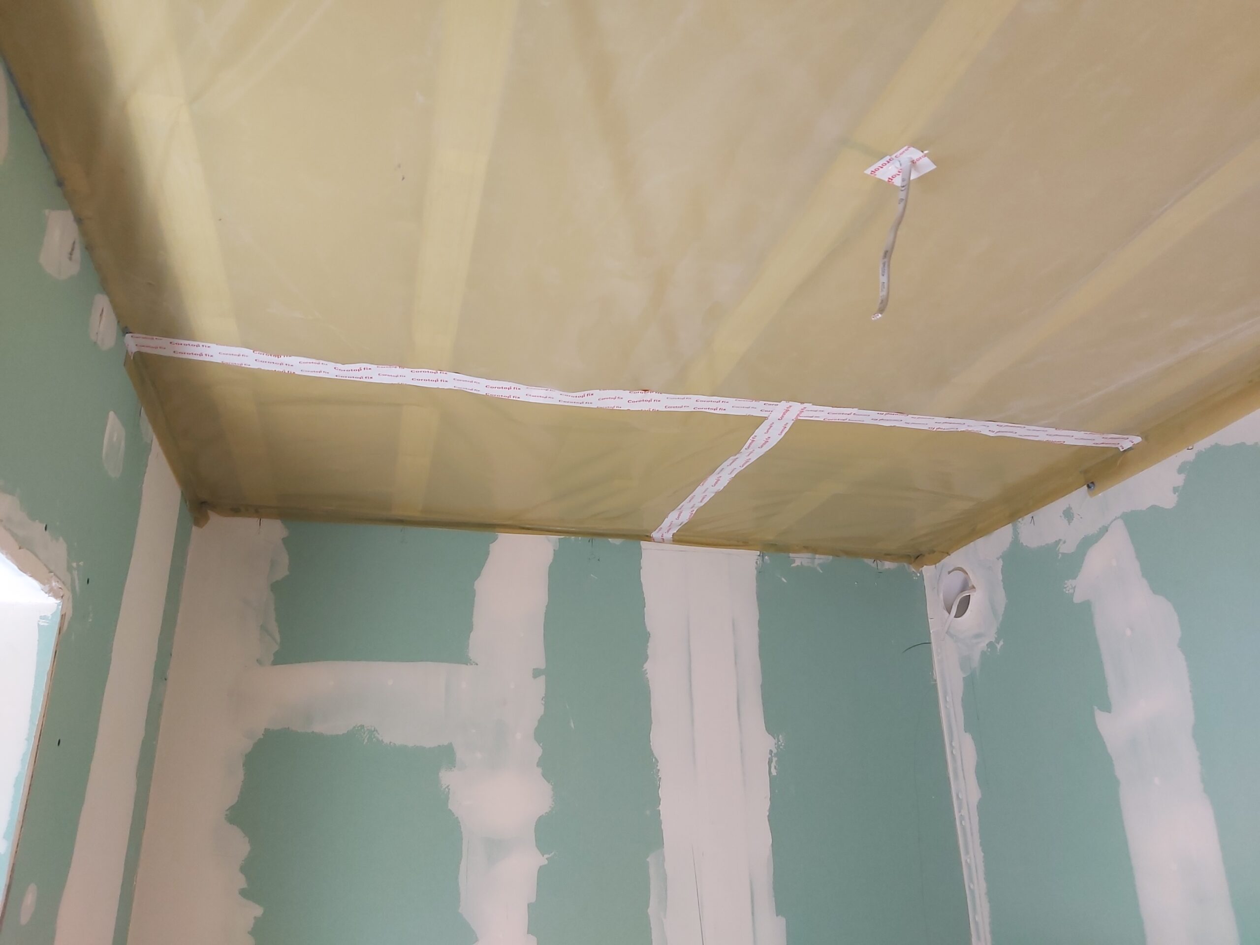 Sufit z folią paroizolacyjną oraz taśmami uszczelniającymi, ściany z płyt gipsowo-kartonowych przygotowane do szpachlowania