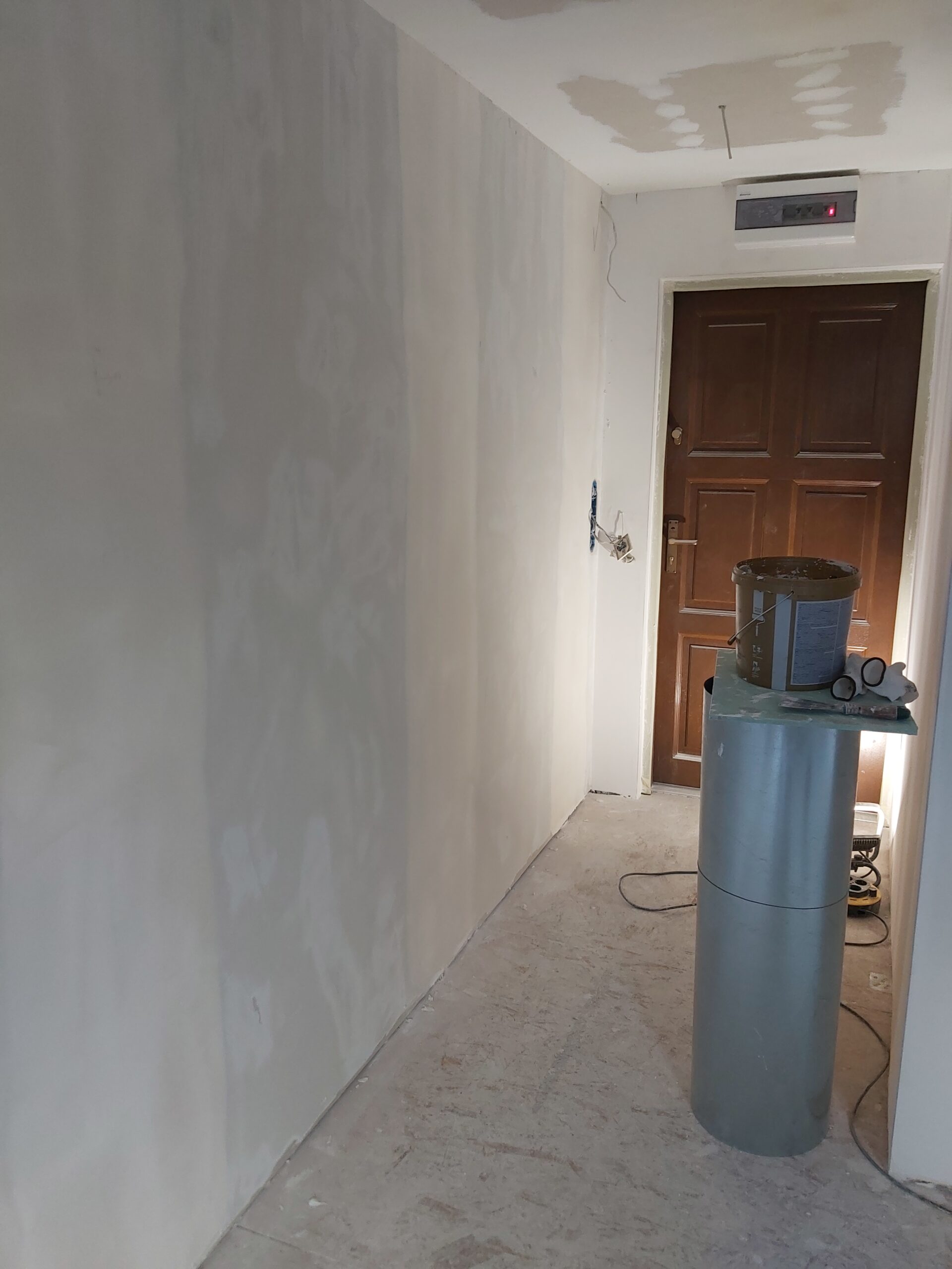 Korytarz po szpachlowaniu ścian i sufitu podczas remontu