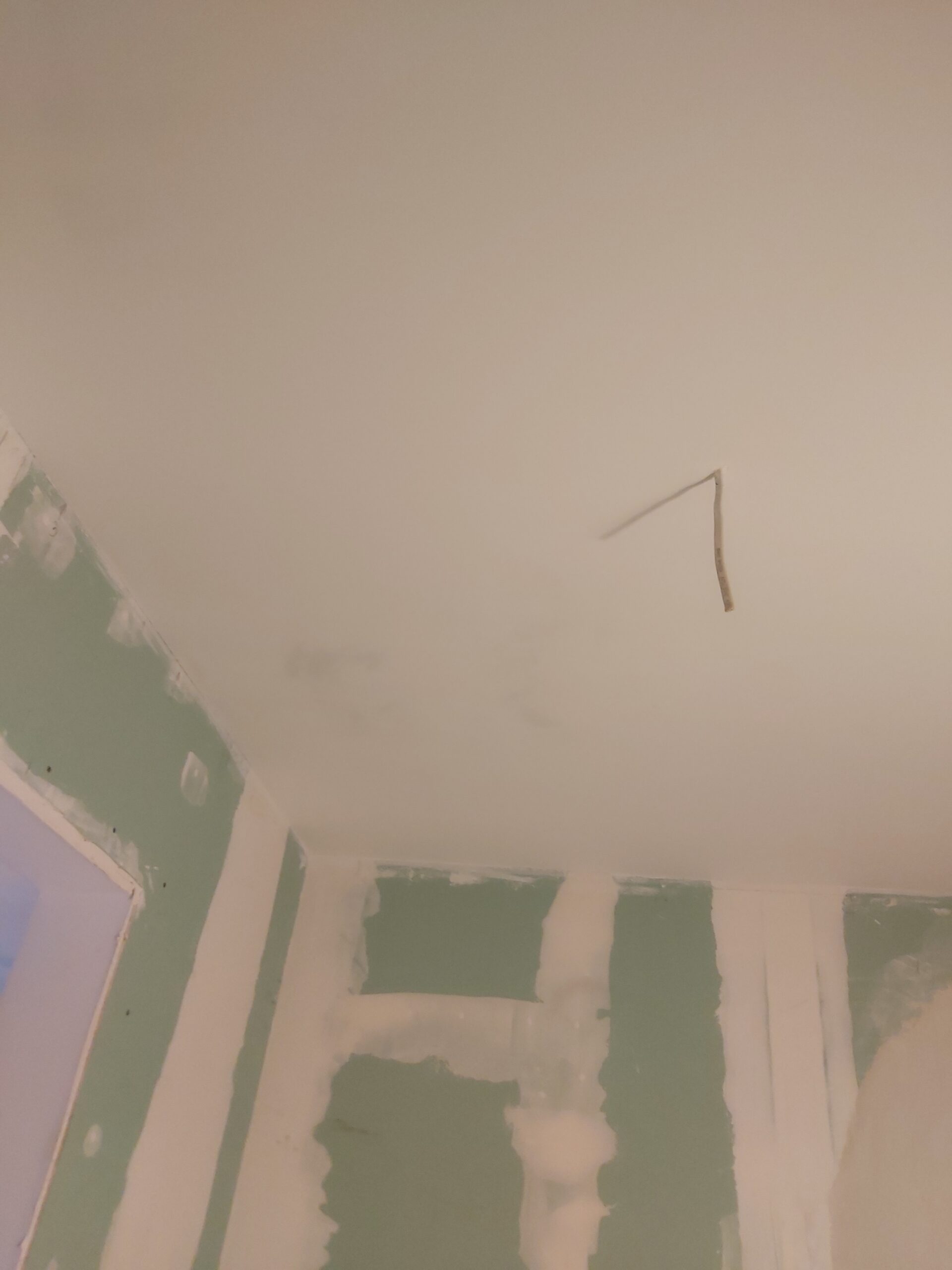 : Sufit z płyt gipsowo-kartonowych z wyprowadzonym przewodem elektrycznym oraz ściana g-k ze spoinami po szpachlowaniu