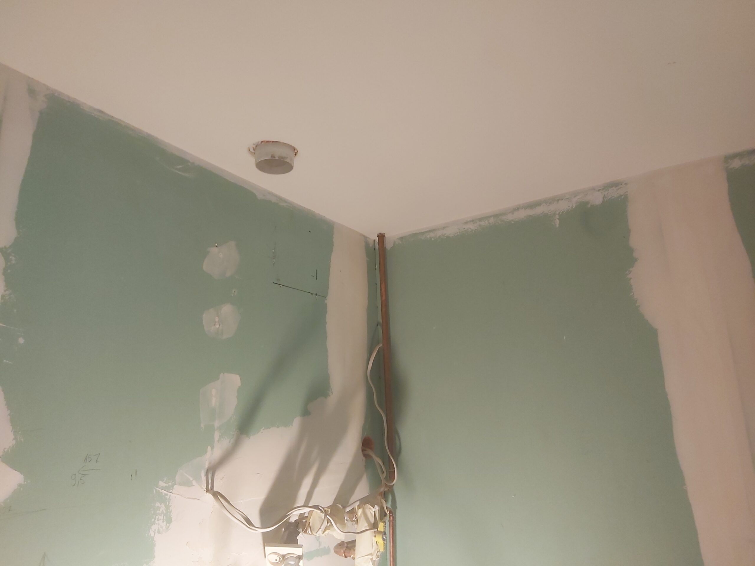 Narożnik ścian z płyt gipsowo-kartonowych z widoczną instalacją elektryczną przed zabudową i szpachlowaniem