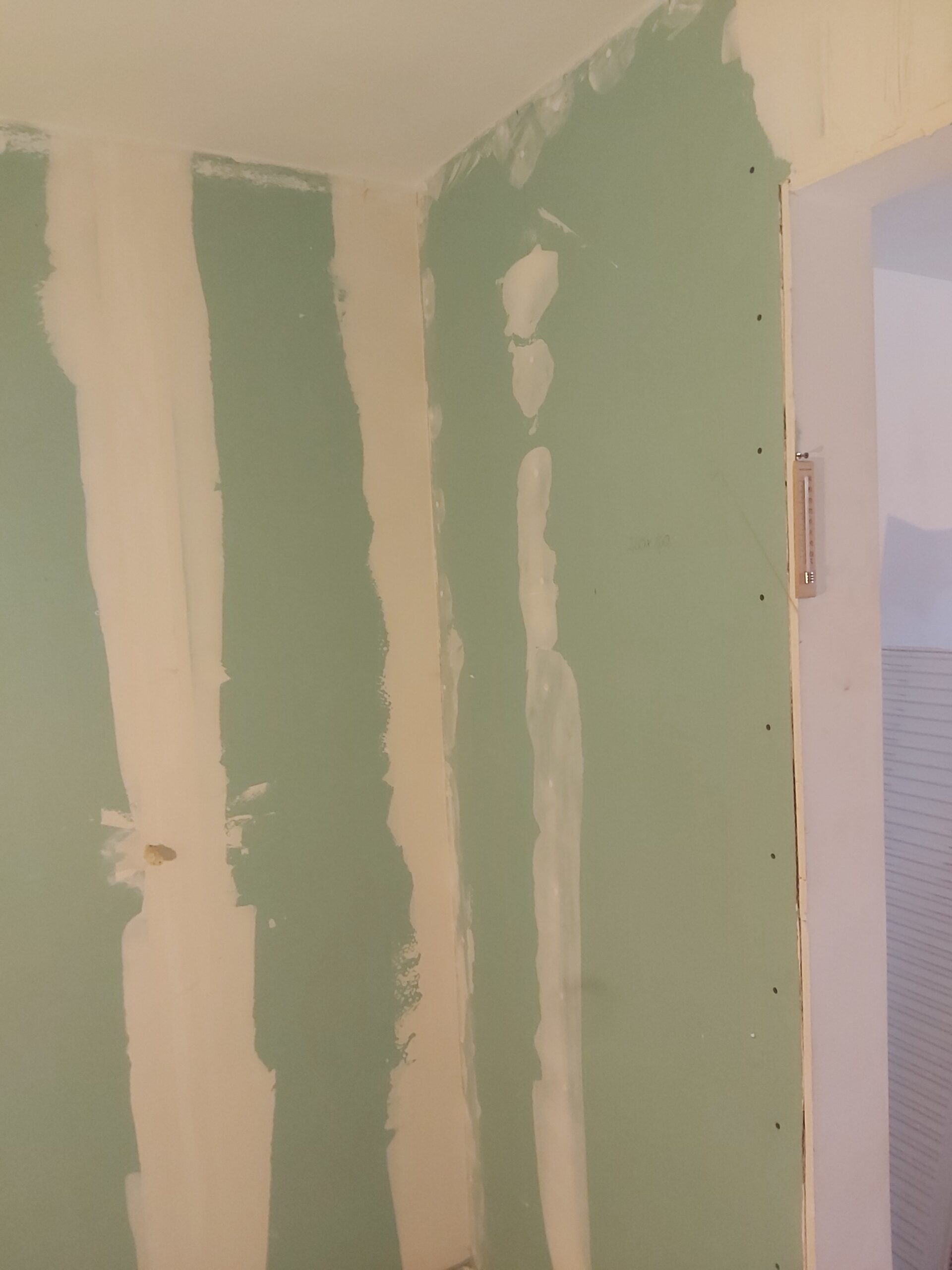 Szpachlowanie łączeń płyt gipsowo-kartonowych na ścianie przy otworze drzwiowym