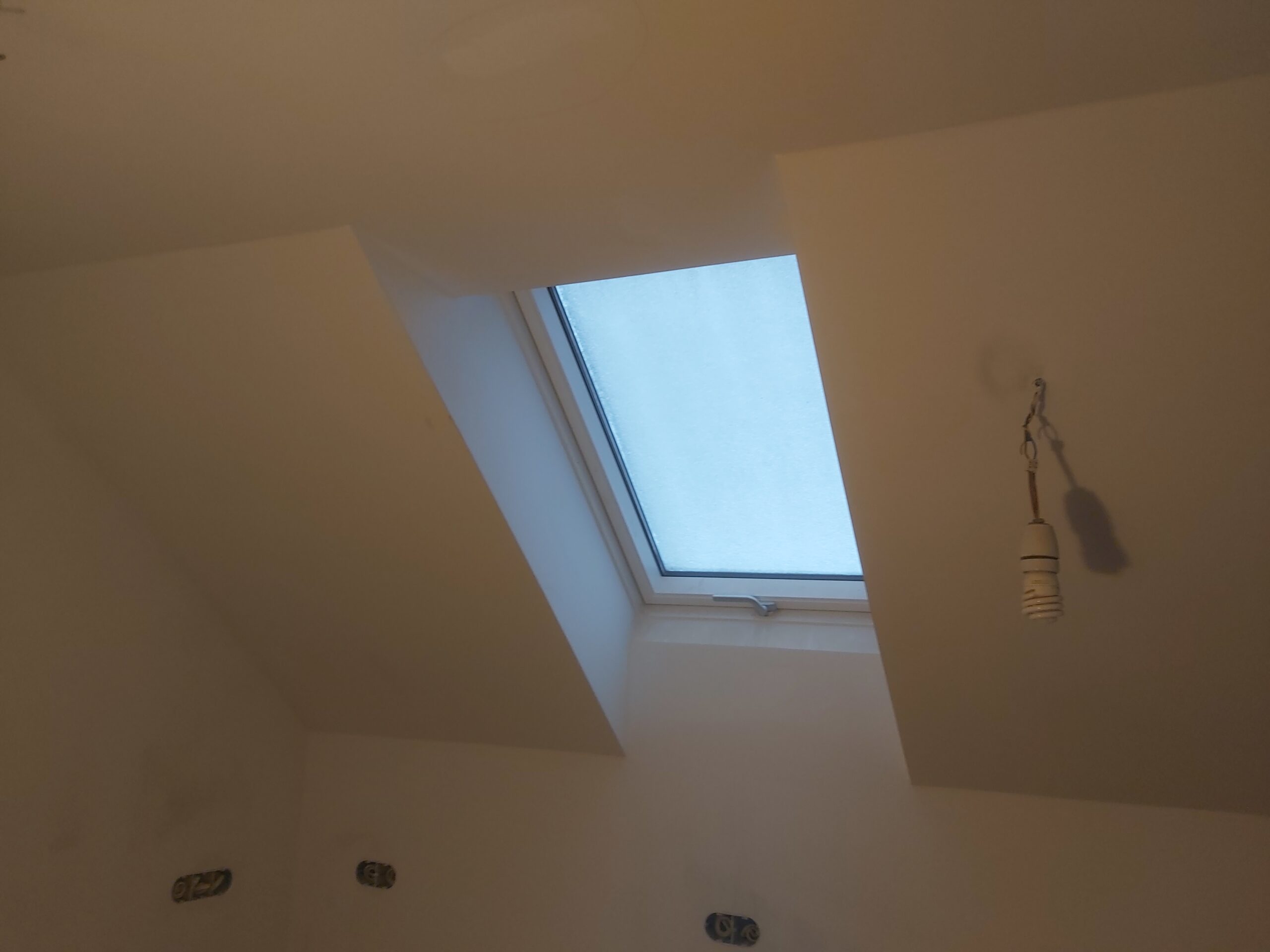 Okno dachowe po wykończeniu, widok od wewnątrz z gładkimi skosami
