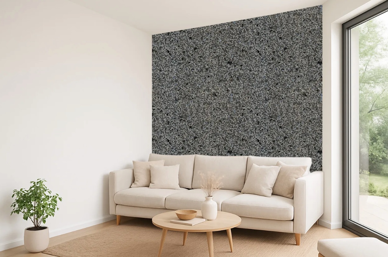 Nowoczesny salon z beżową sofą, stolikiem kawowym i dekoracyjną ścianą o fakturze granitu.