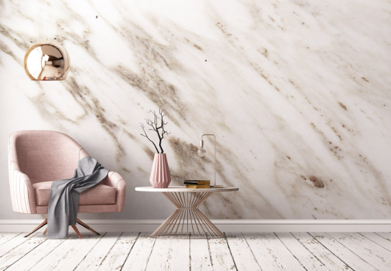 Dekoracyjna ściana ze stiuku weneckiego z efektem jasnego marmuru w eleganckim salonie z fotelem i stolikiem.